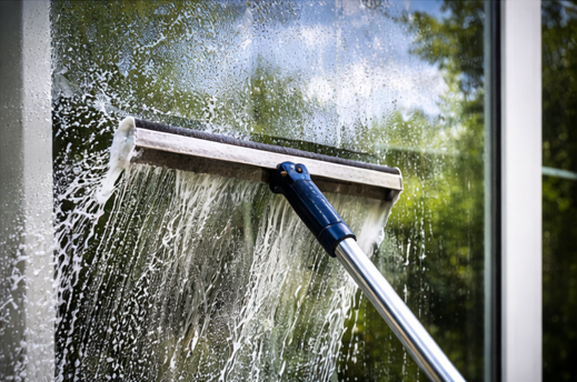Professional window cleaning service removing dirt and streaks from residential and commercial glass